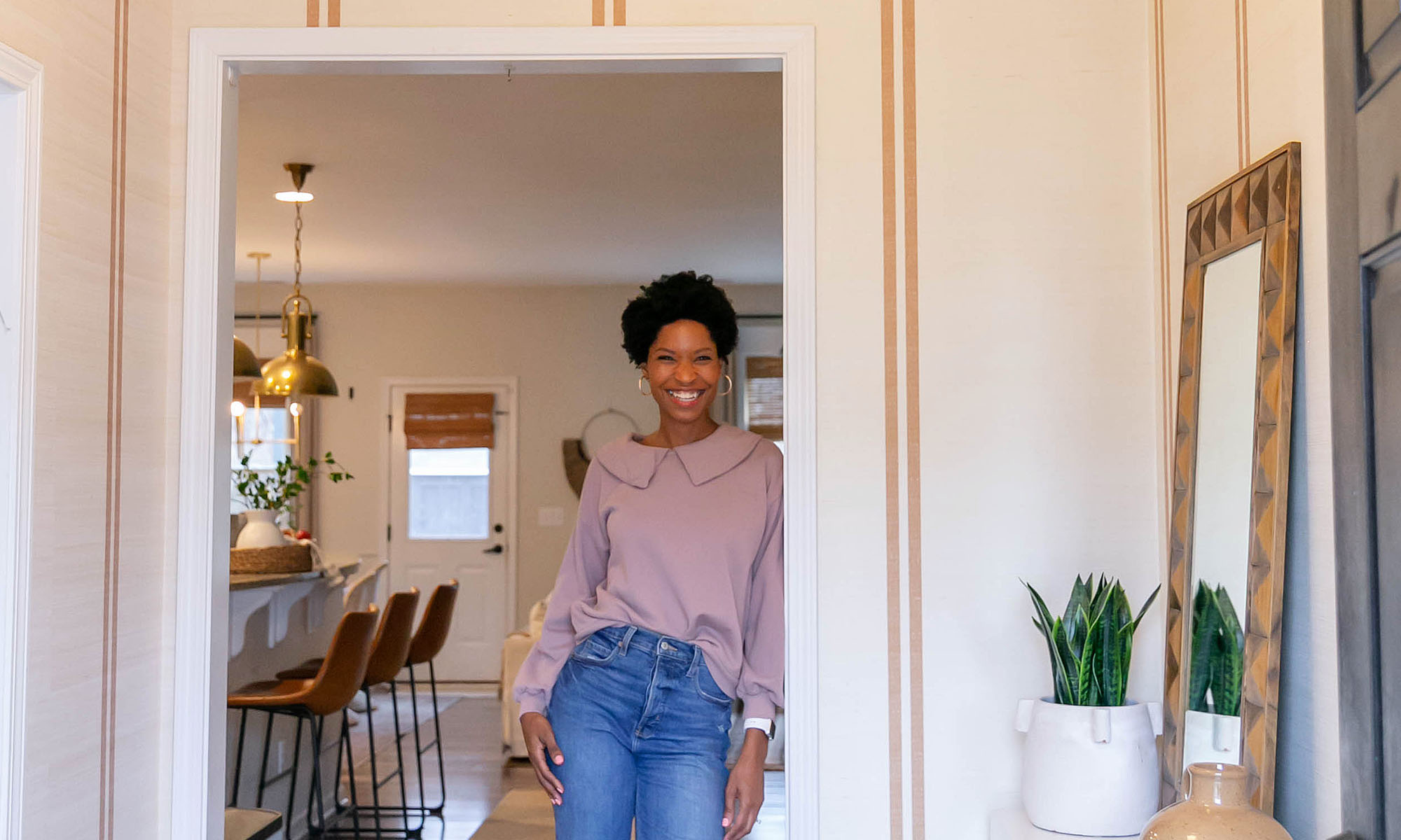 Tiffany DeLangie of Pretty Real Blog holding a wallpaper swatch.