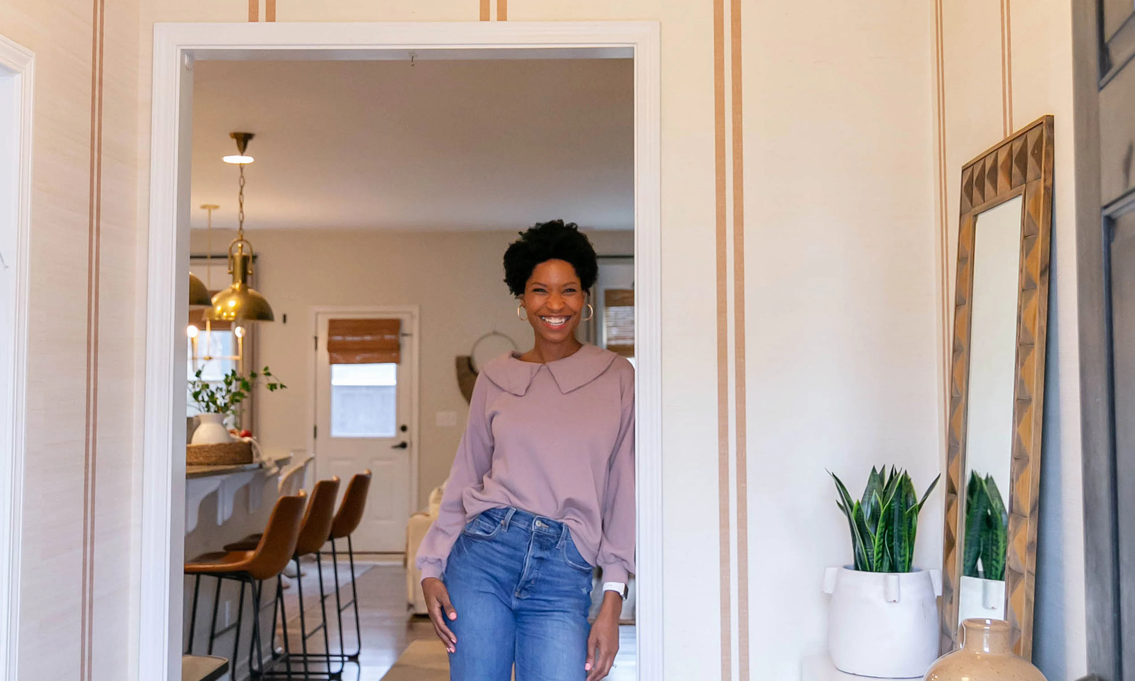 Tiffany DeLangie of Pretty Real Blog holding a wallpaper swatch.