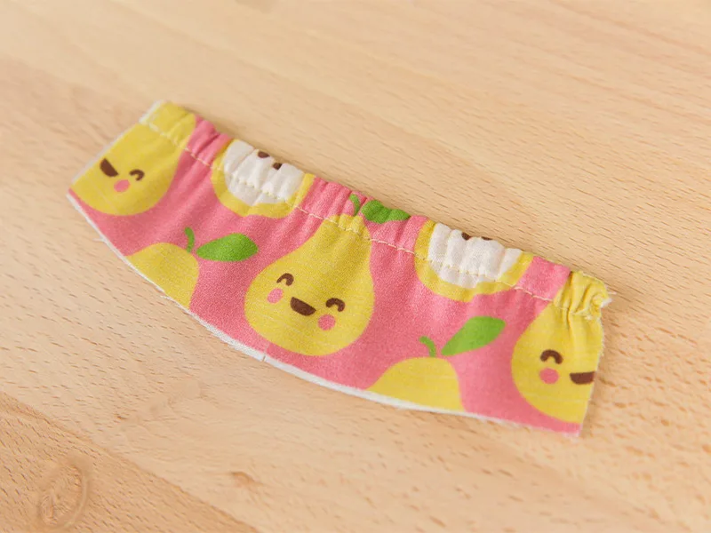 An elastic piece of fabric lays on a wooden surface.