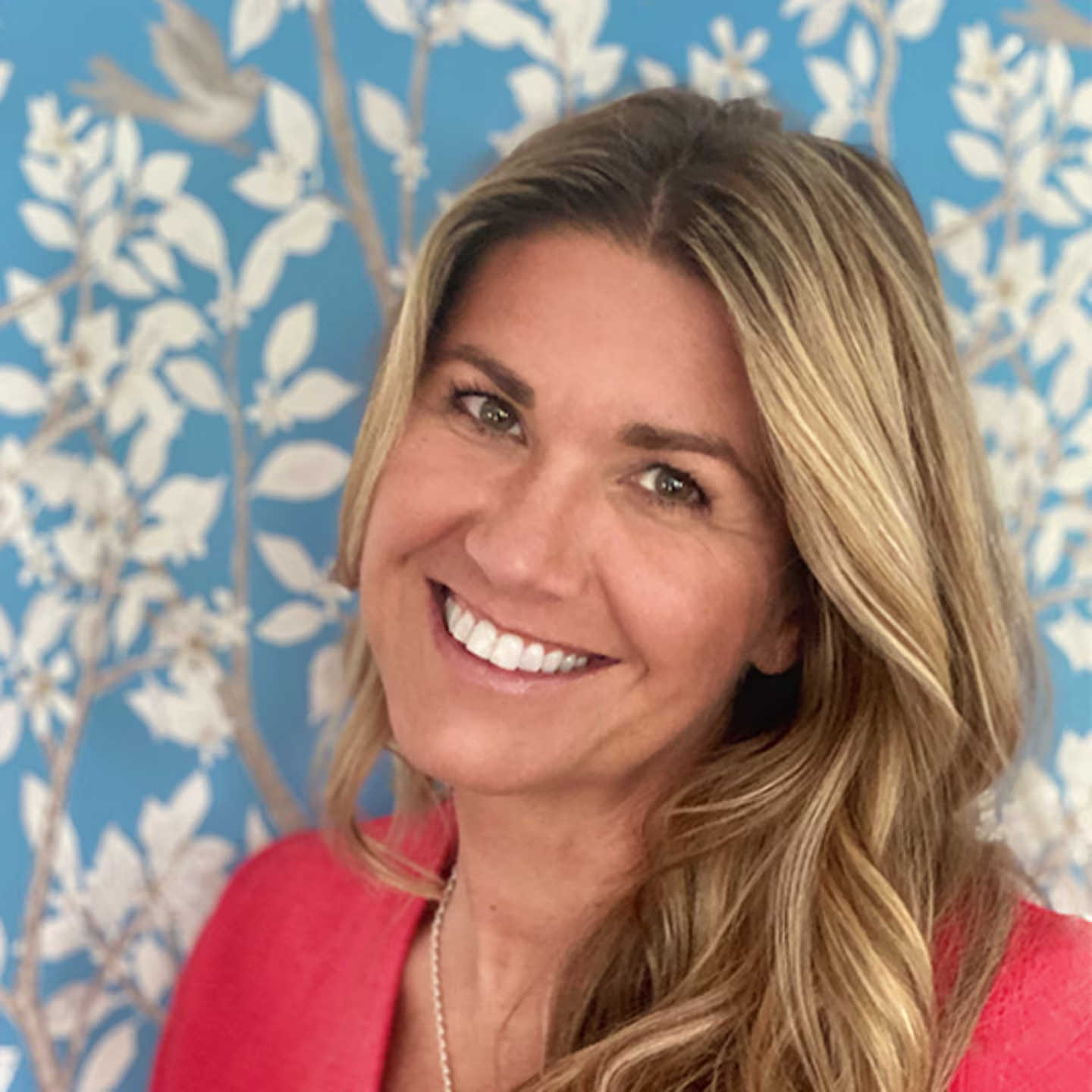 Headshot of Danika Herrick In front of her design on Spoonflower wallpaper.