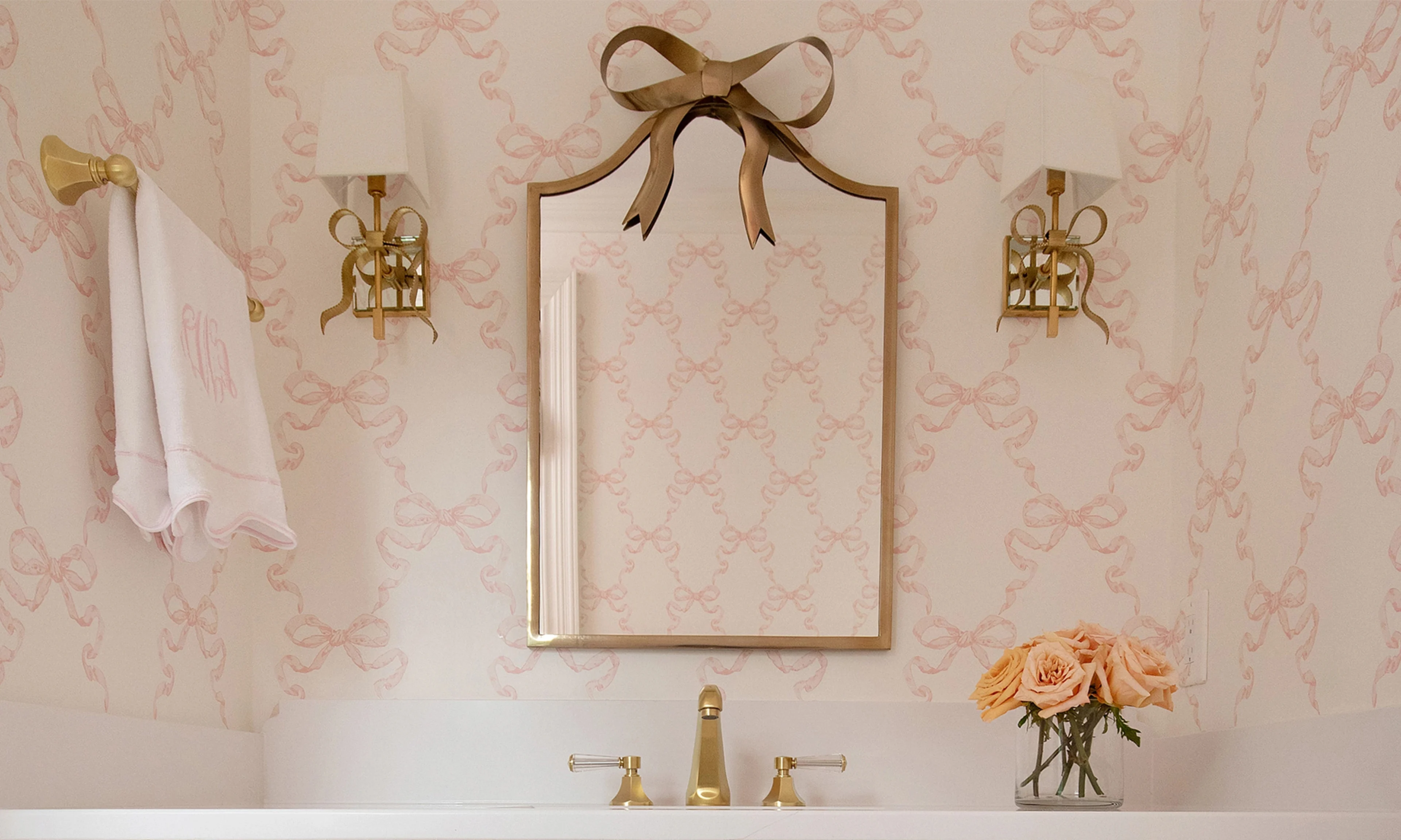 Bathroom with pink bow wallpaper.