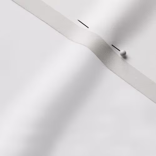 A close-up photo of white fabric with a pin running through it