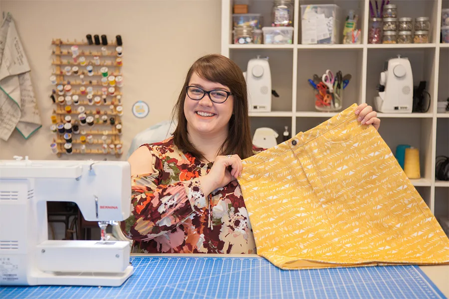 MaryAshlyn holds up her finished yellow denim skirt.