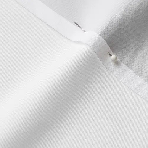 A close-up photo of white fabric with a pin running through it