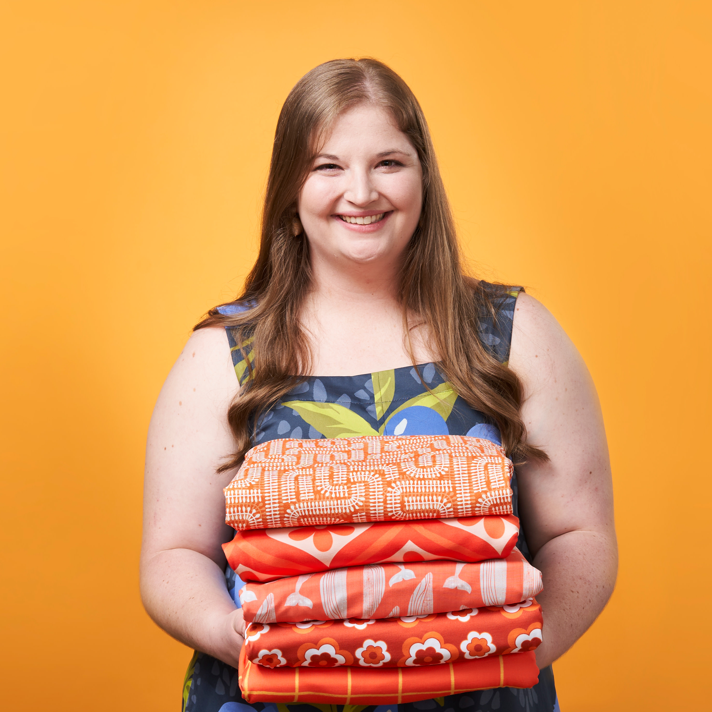 Person holding folded orange fabrics