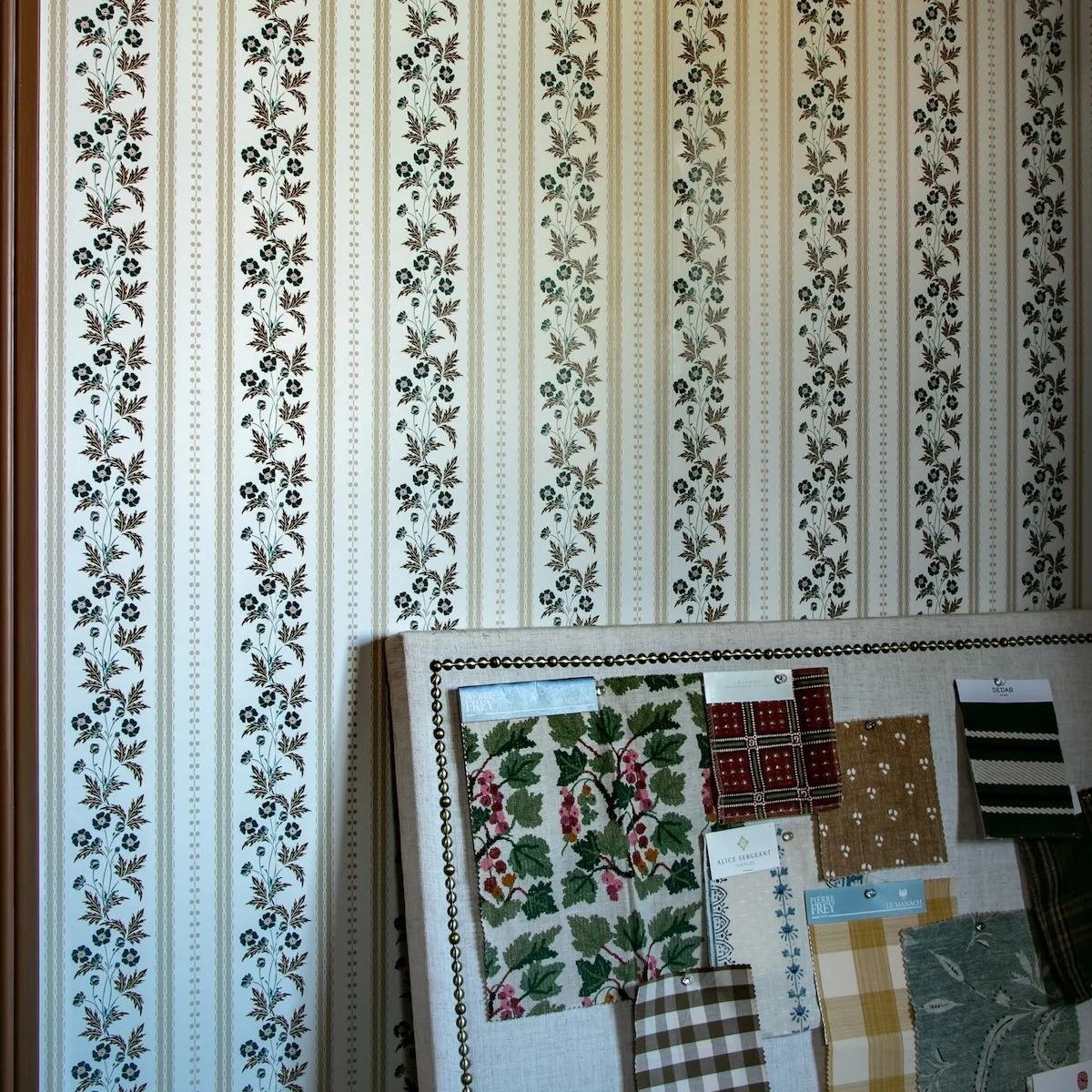 A moodboard resting against a wallpapered wall