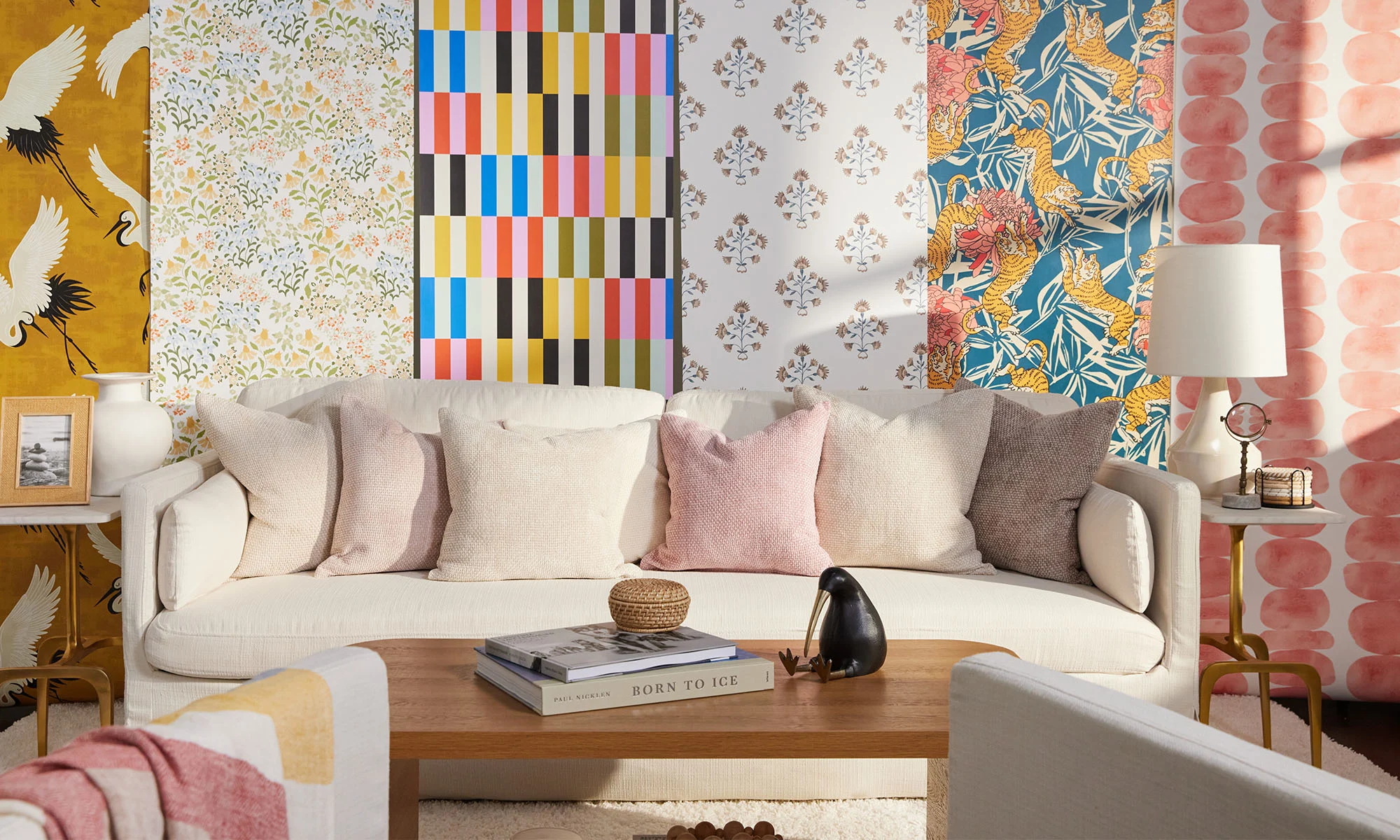 A living room scene with different rolls of colorful geometric, floral, and boho wallpaper