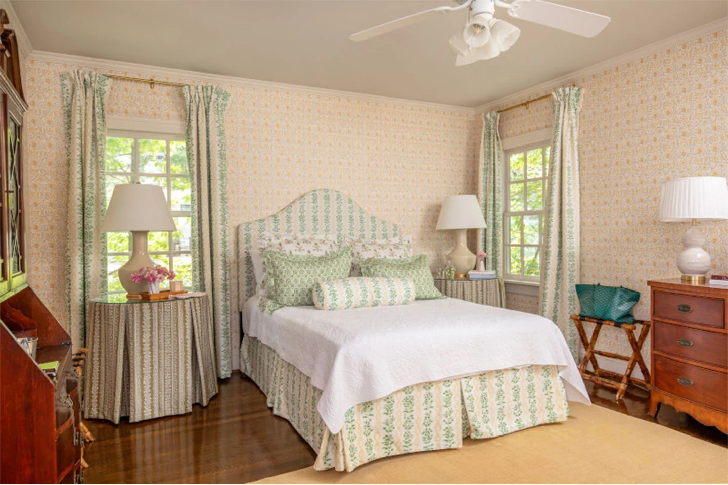 Traditional bedroom with green and pink color scheme across bedding, wallpaper, and curtains.