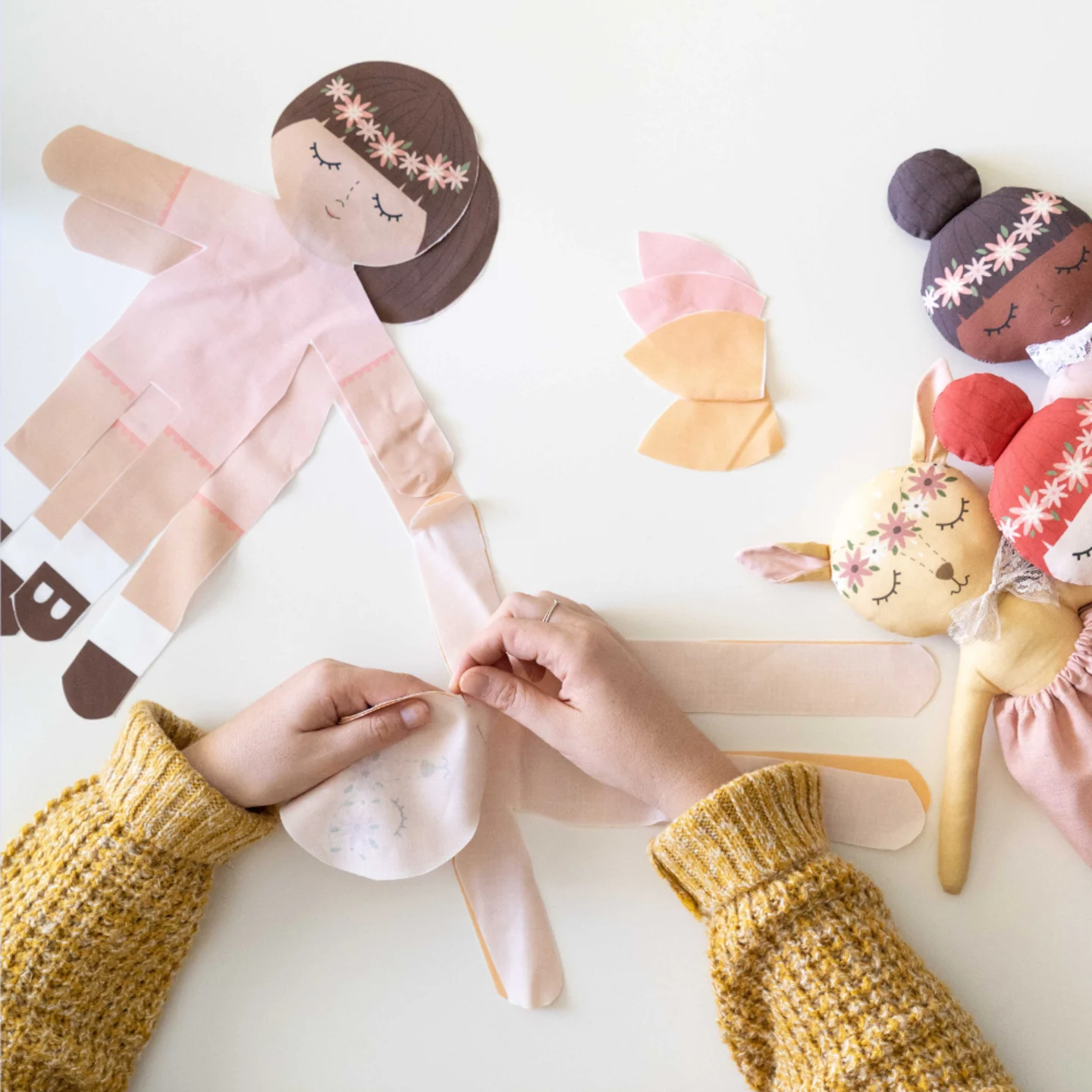 little kids hands working on a cut and sew doll.