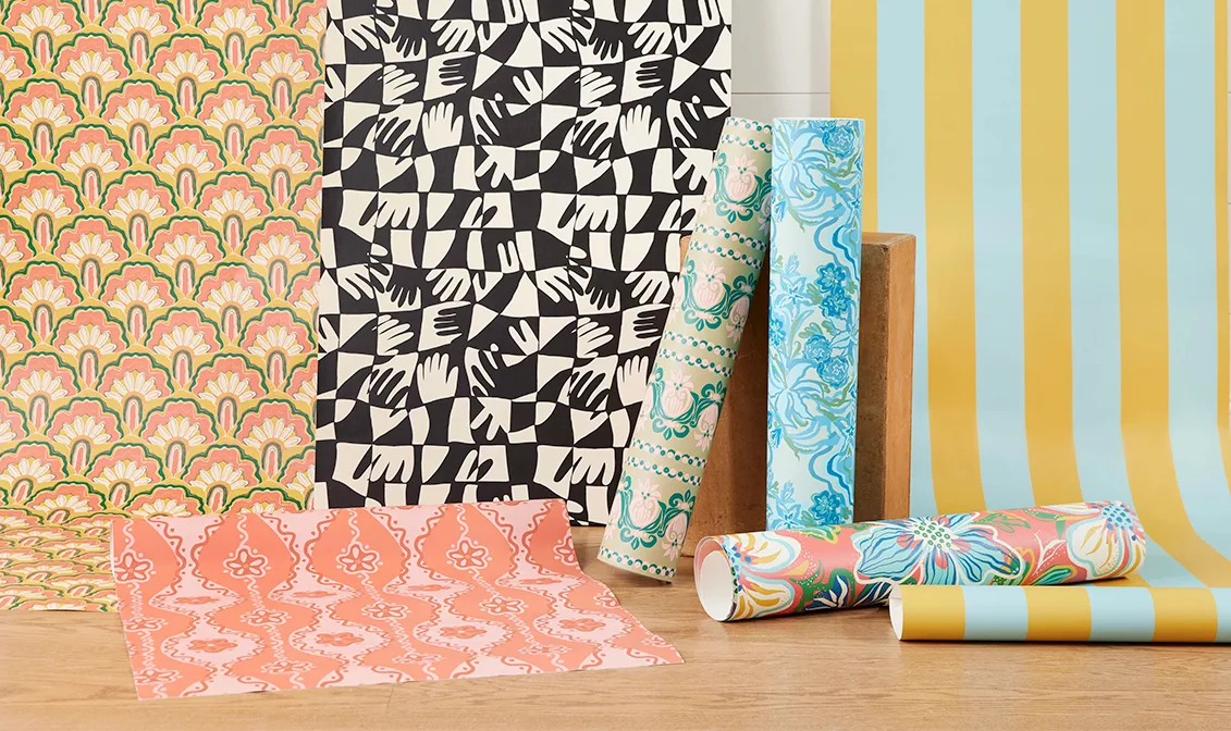 Rolls of wallpaper with Dani Dazey designs on display.