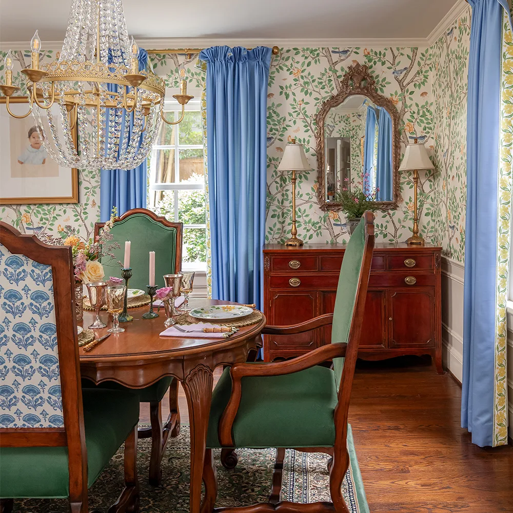 Dining room with wallpaper in Elsie's Garden Butterscotch on cream and blue curtains.