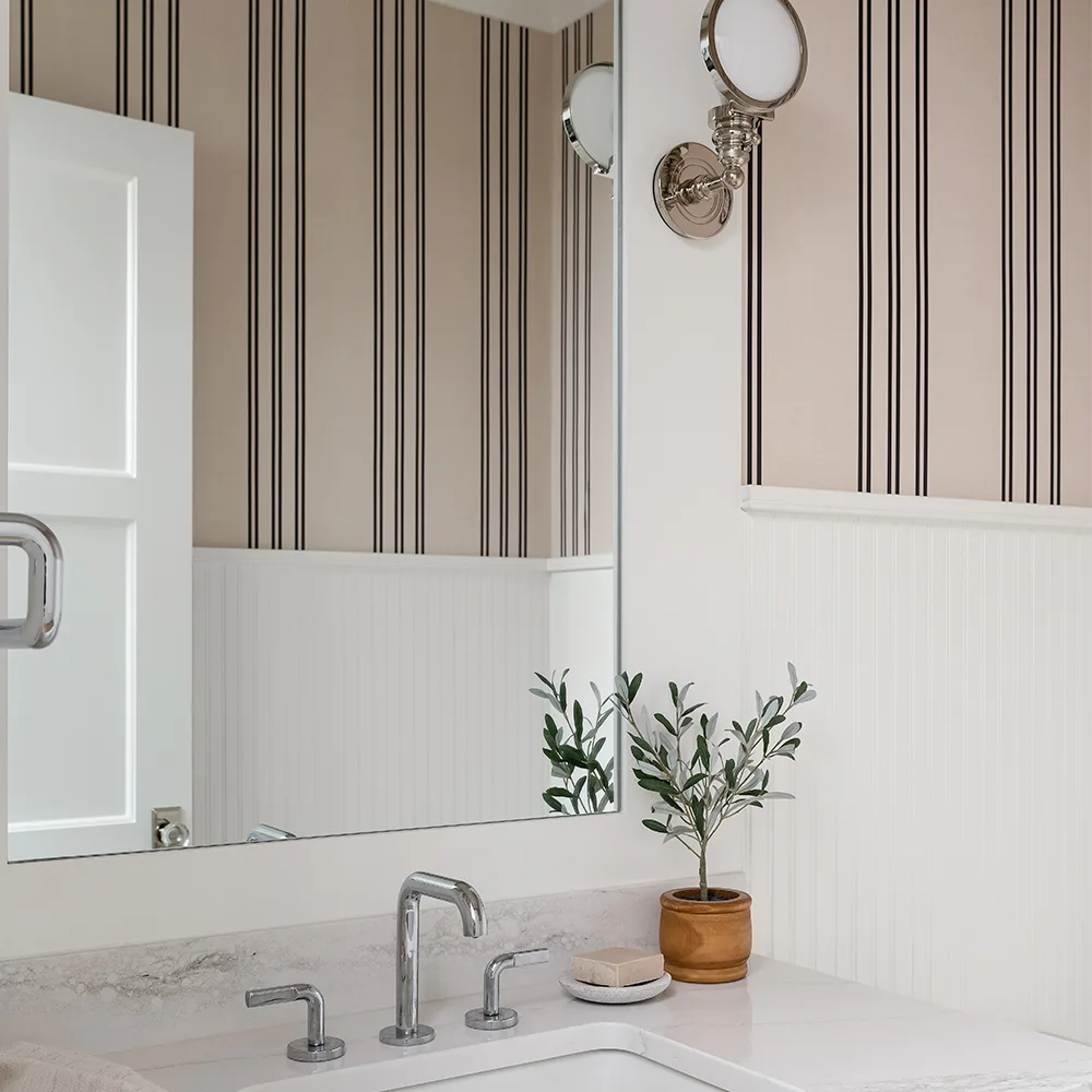 Bathroom with tan and black striped wallpaper.