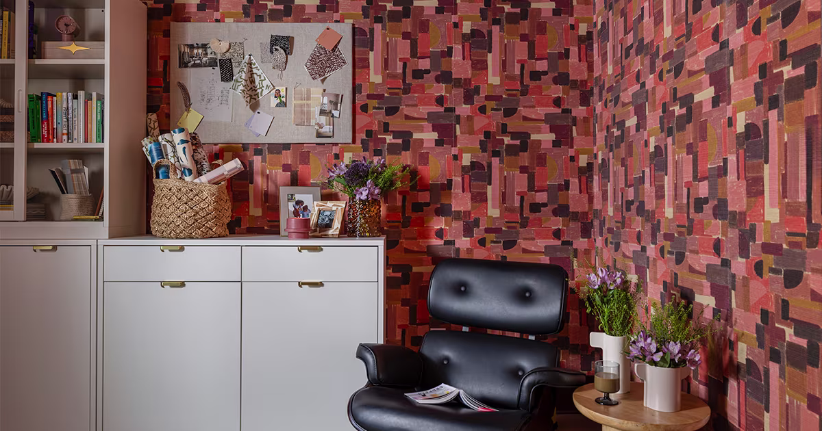 Home office space with pink geometric wallpaper.