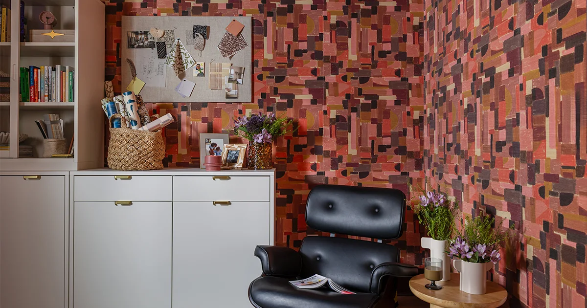 Home office space with pink geometric wallpaper.
