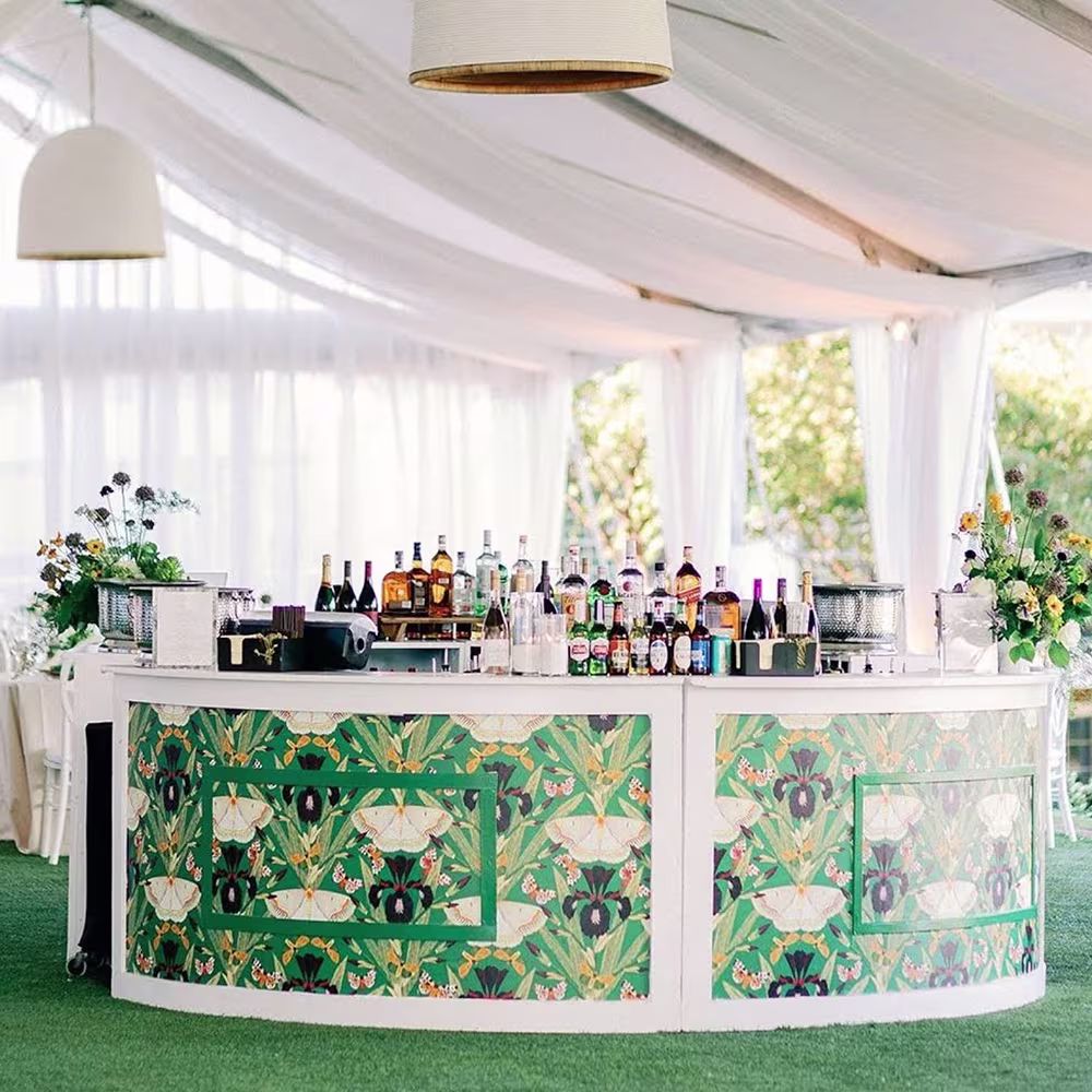 Wedding bar with moth and iris wallpaper around the bottom and fabric draped across the ceiling.