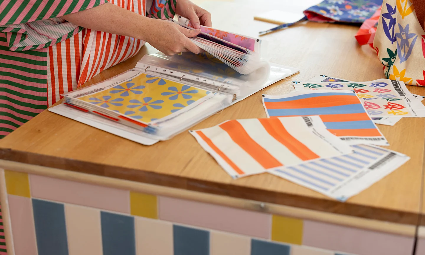 Person holding fabric swatches.