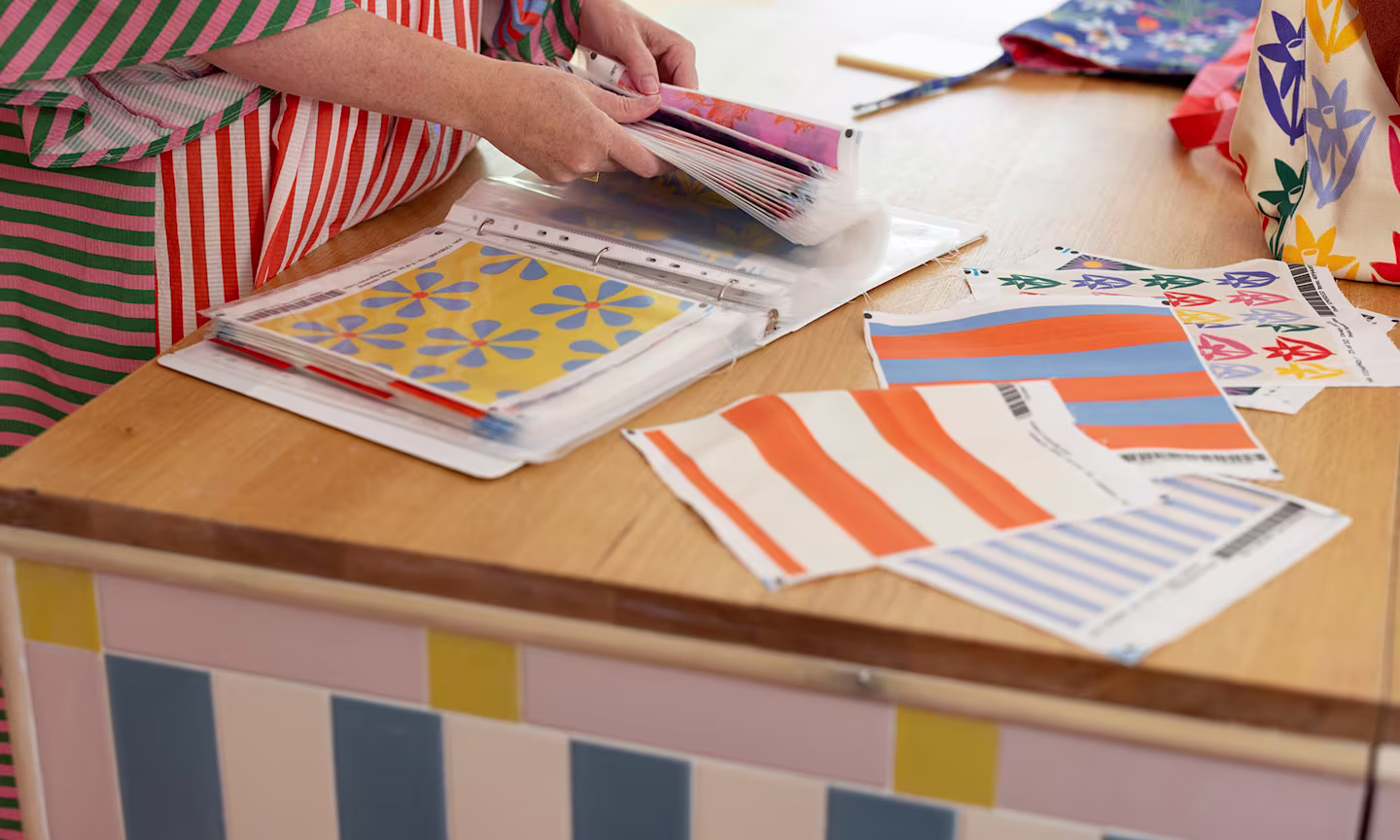 Person holding fabric swatches.