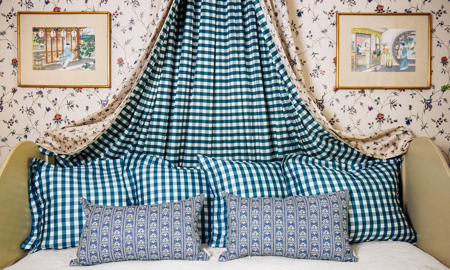 Guest bed with teal gingham shams and euro shams plus blue block print pattern lumbar throw pillows.