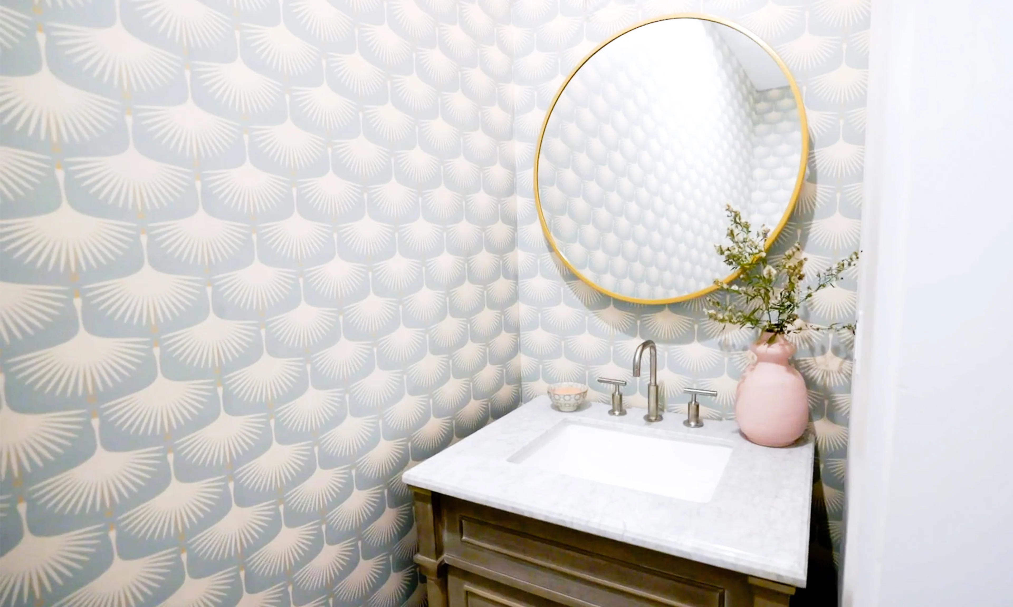 Bathroom wallpapered with light blue and white cranes.