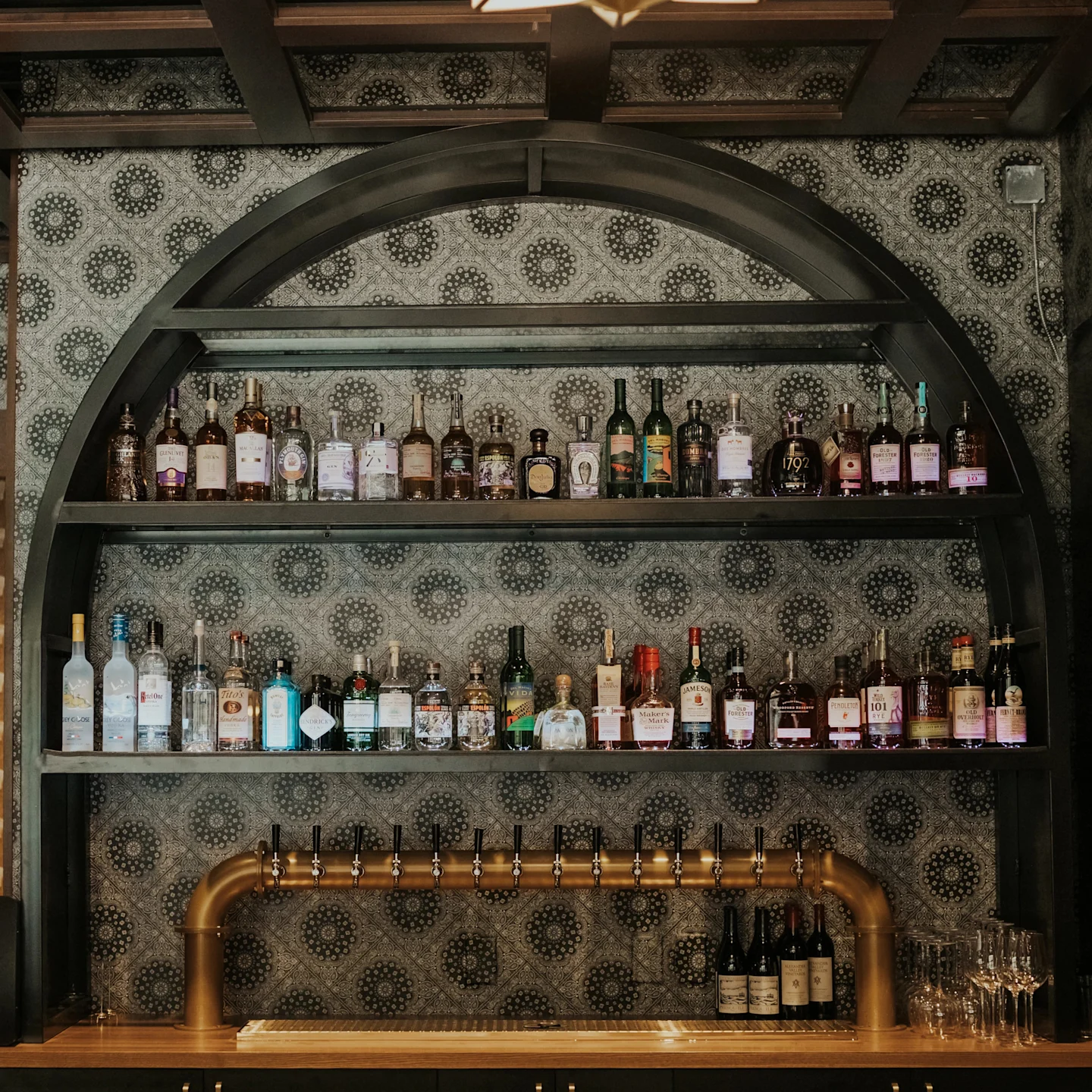 Monochrome botanical wallpaper behind bar shelving.