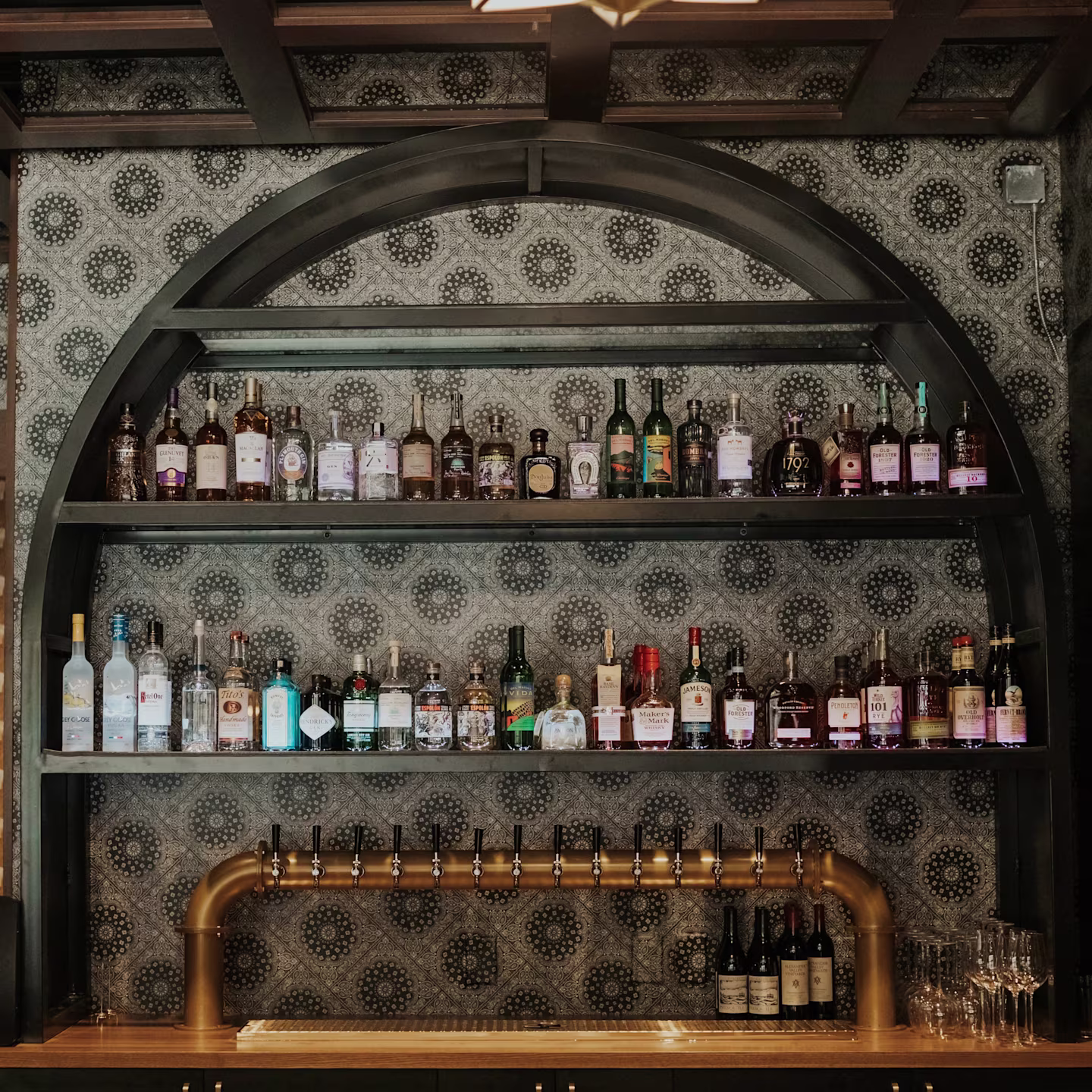 Monochrome botanical wallpaper behind bar shelving.