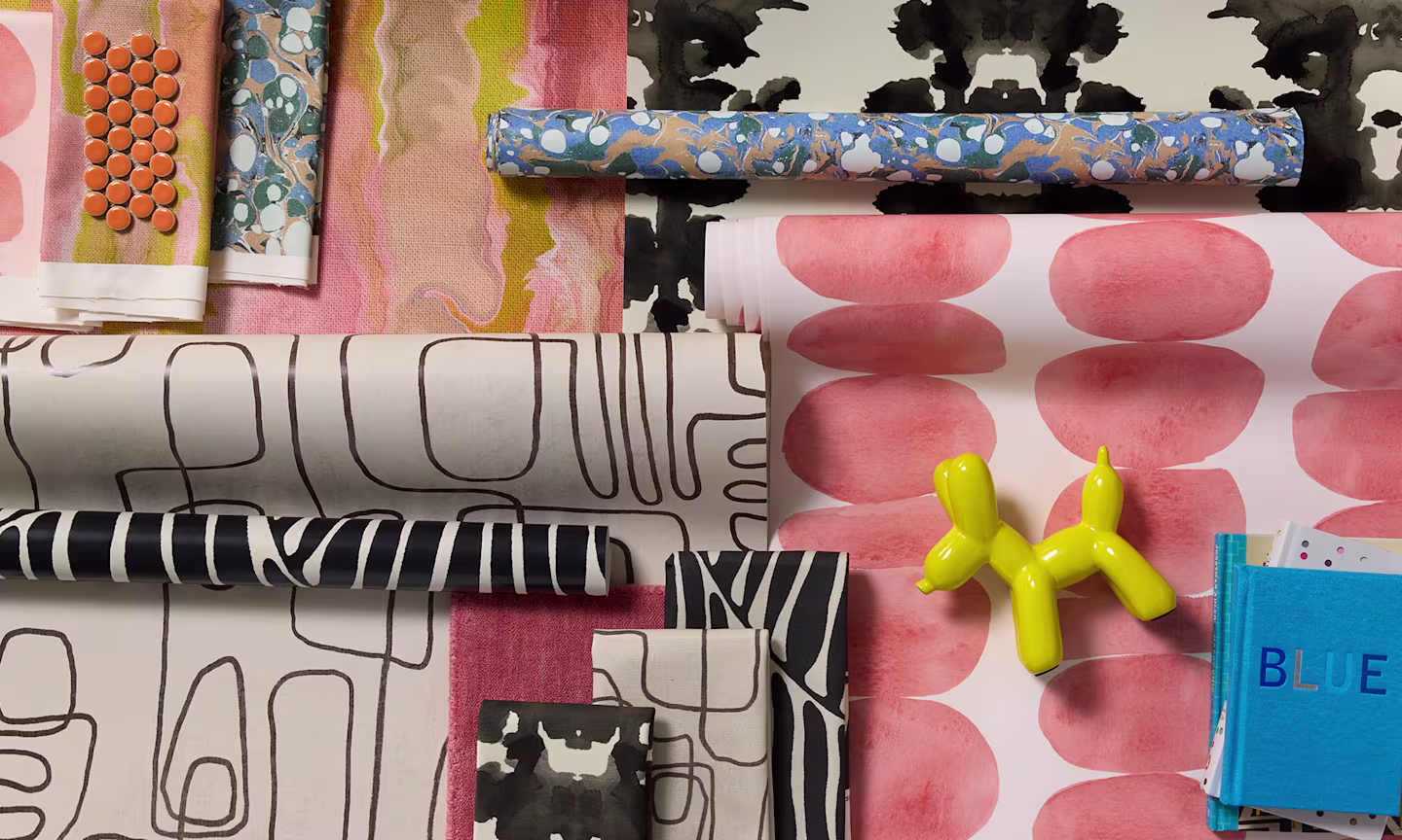 Modern style wallpaper rolls and fabric swatches.