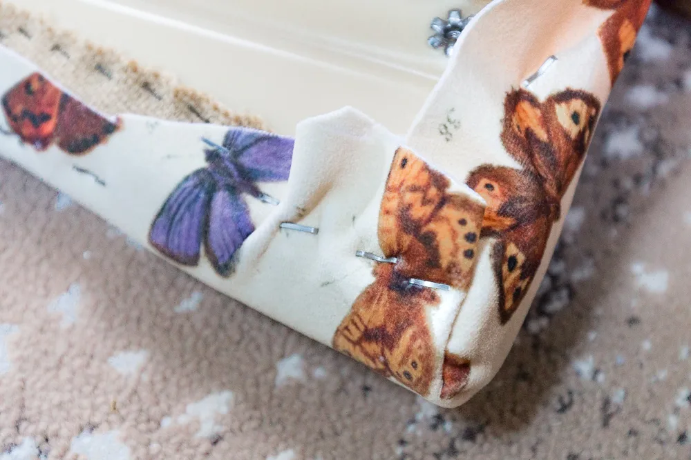 Upholstery fabric stapled to corner of chair