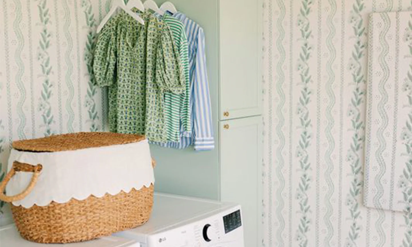 Laundry room with blue and green floral stripe wallpaper.