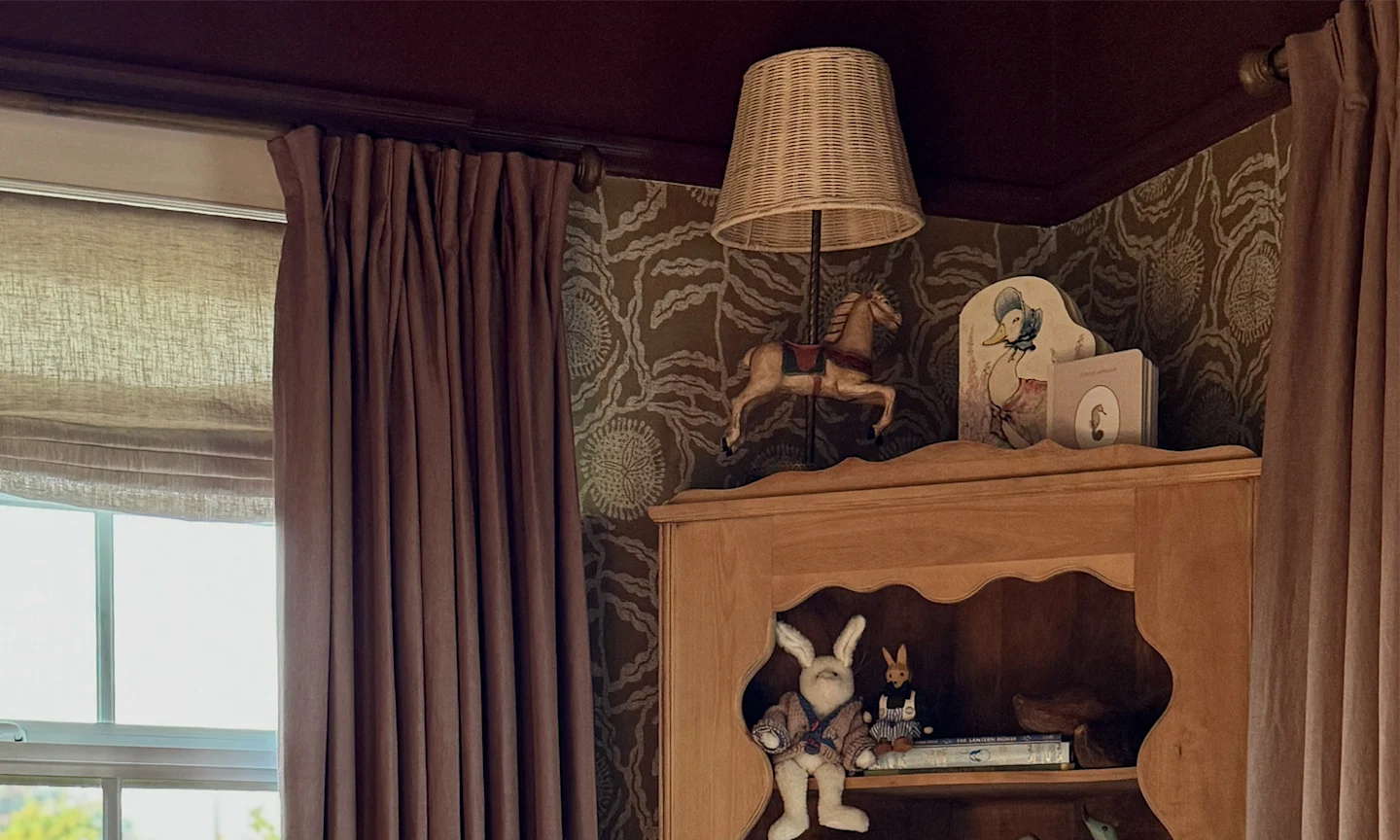 Nursery with neutral floral wallpaer and a purple ceiling and matching curtains