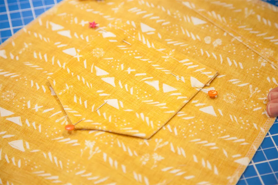 A close up of one of the back pockets penned to the skirt using sewing pins in preparation for sewing.