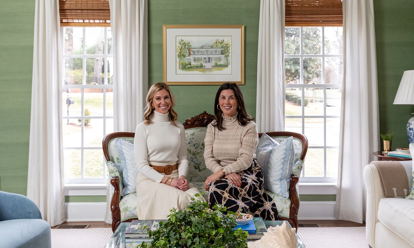 Caroline Walker and Maddie Hazelgrove in a living room with green wallpaper.