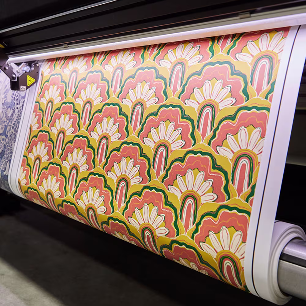 Large-format printers and rolls of printed material in a U.S. workspace.