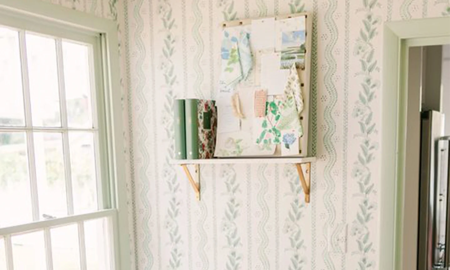Entryway with blue and green floral stipe wallpaper and a floating shelf.