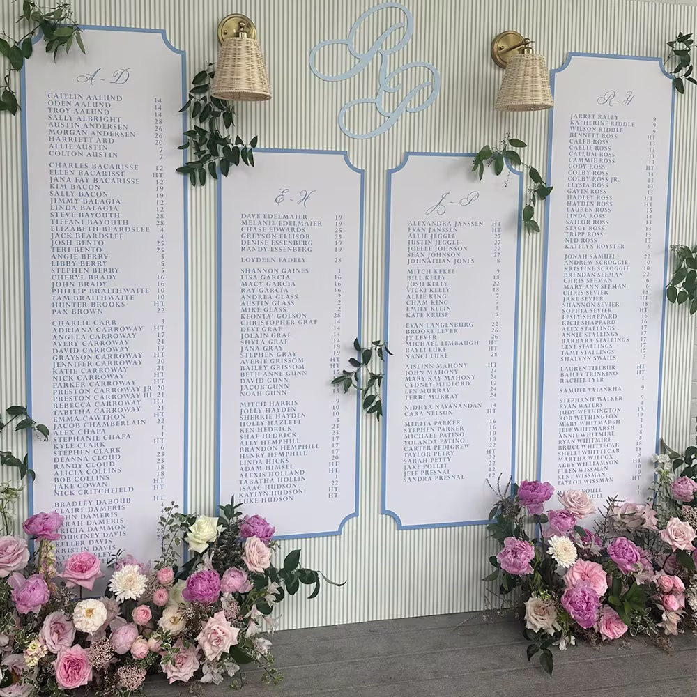 Large scale wedding seating chart with a striped wallpaper background.