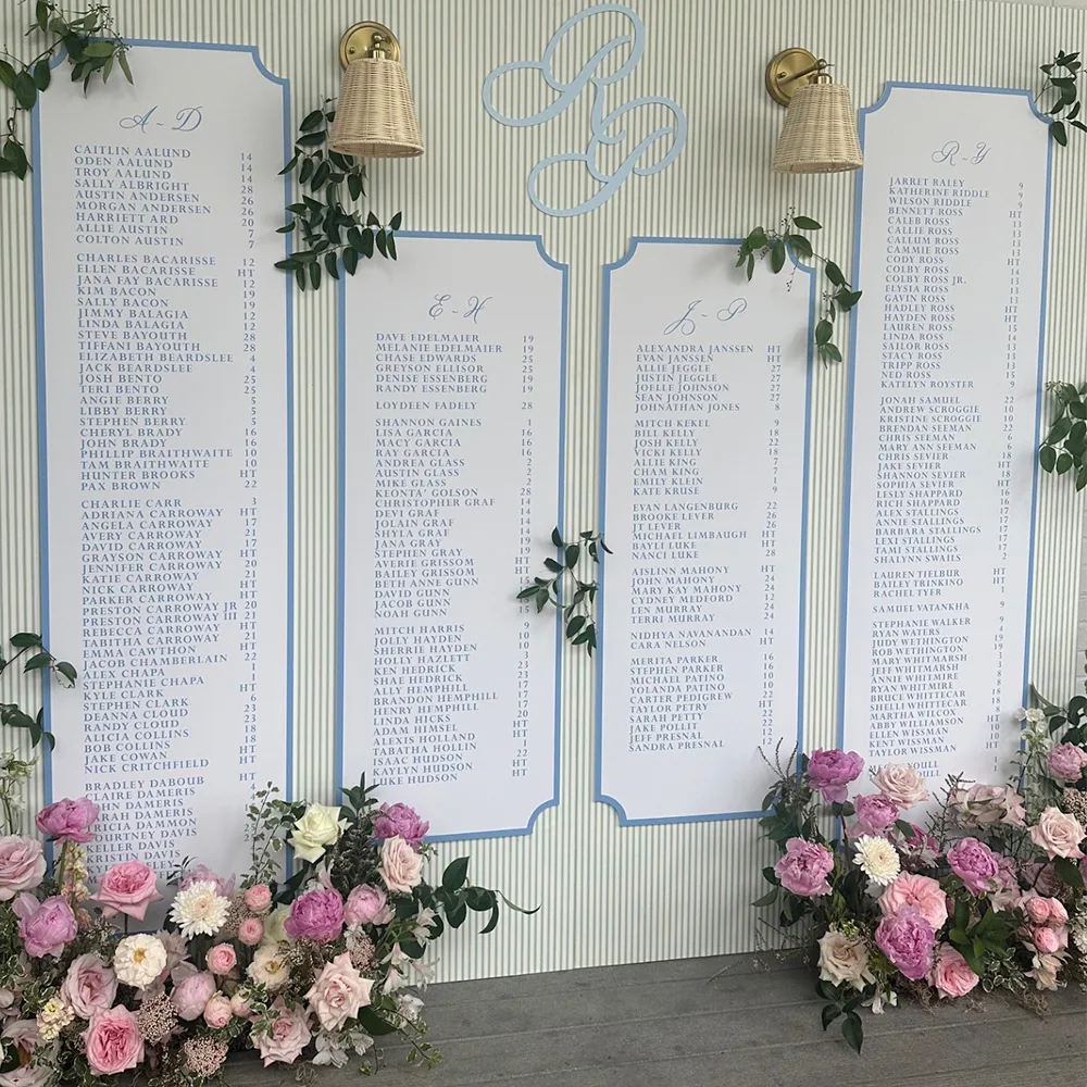 Large scale wedding seating chart with a striped wallpaper background.