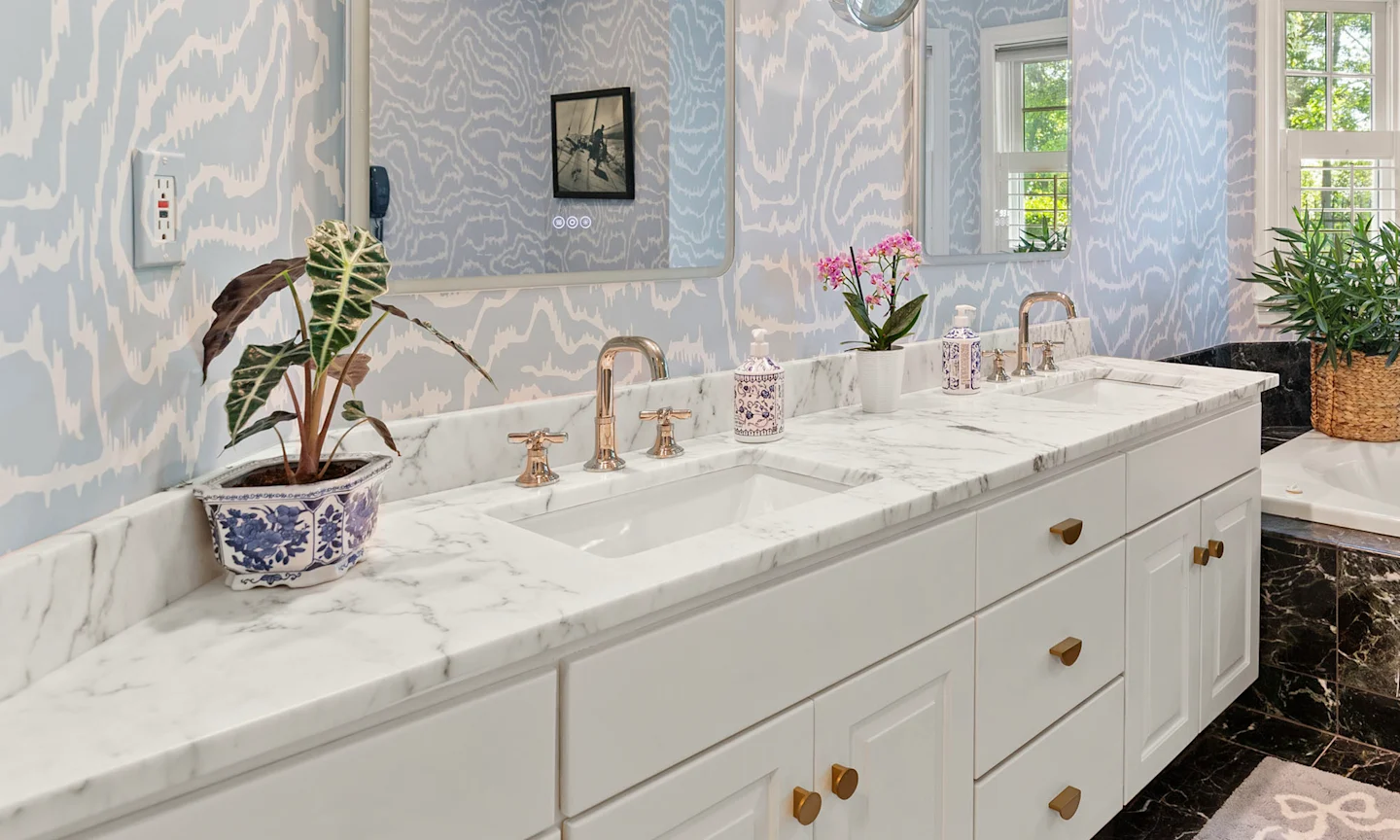 Bathroom with pale blue abstract wallpaper.