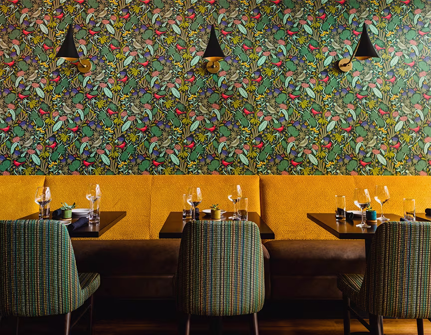 Wallpaper hanging above a restaurant booth.