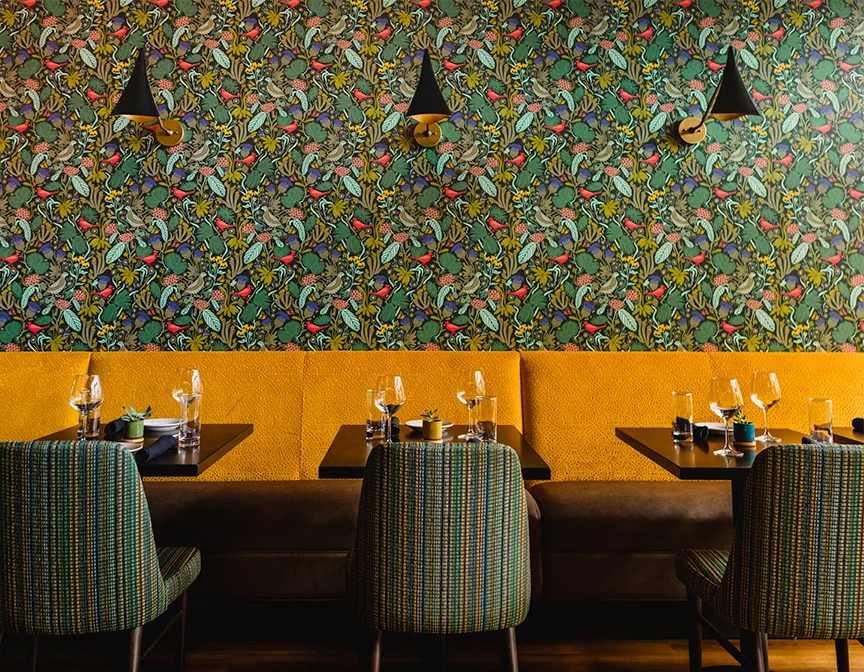 Wallpaper hanging above a restaurant booth.