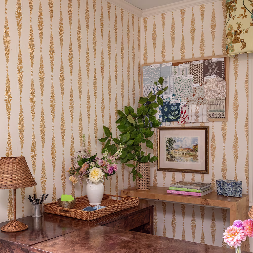 Gold fern leaf on cream vertical stripe wallpaper in a home office.