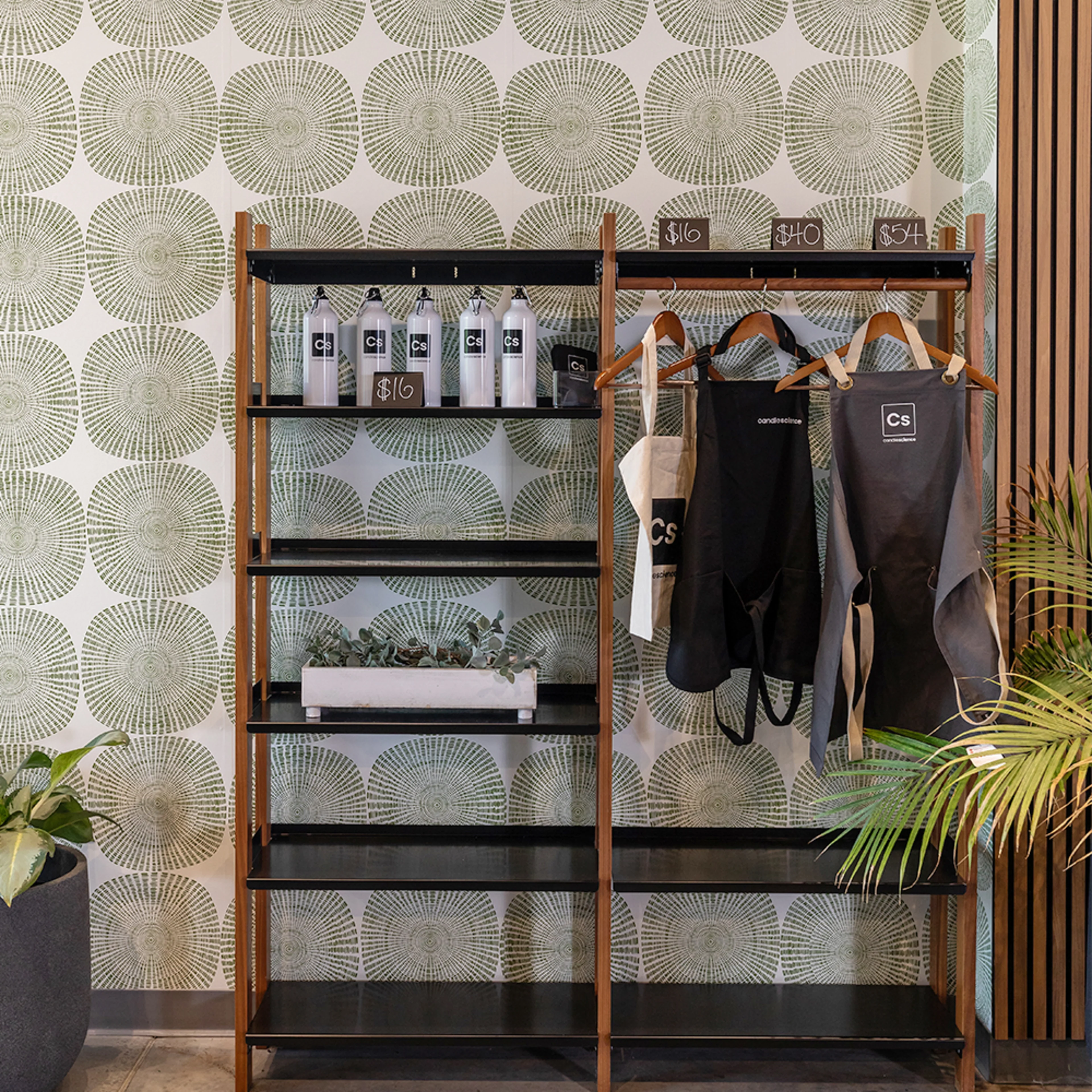 Shelf at Candle Science office with geometric wallpaper behind it.
