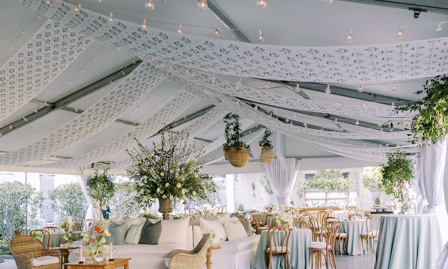 Wedding reception tent with printed floral fabric draped across the ceiling.