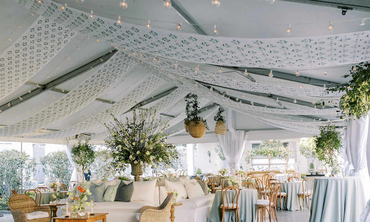 Wedding reception tent with printed floral fabric draped across the ceiling.