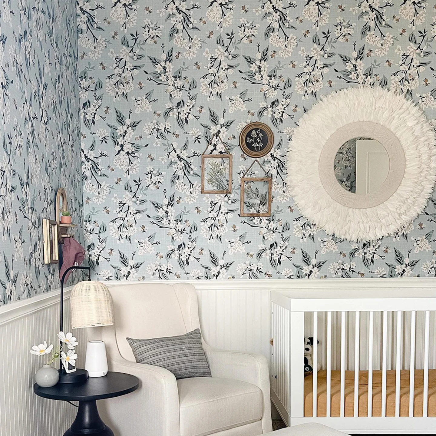 Nursery with blue floral wallpaper.