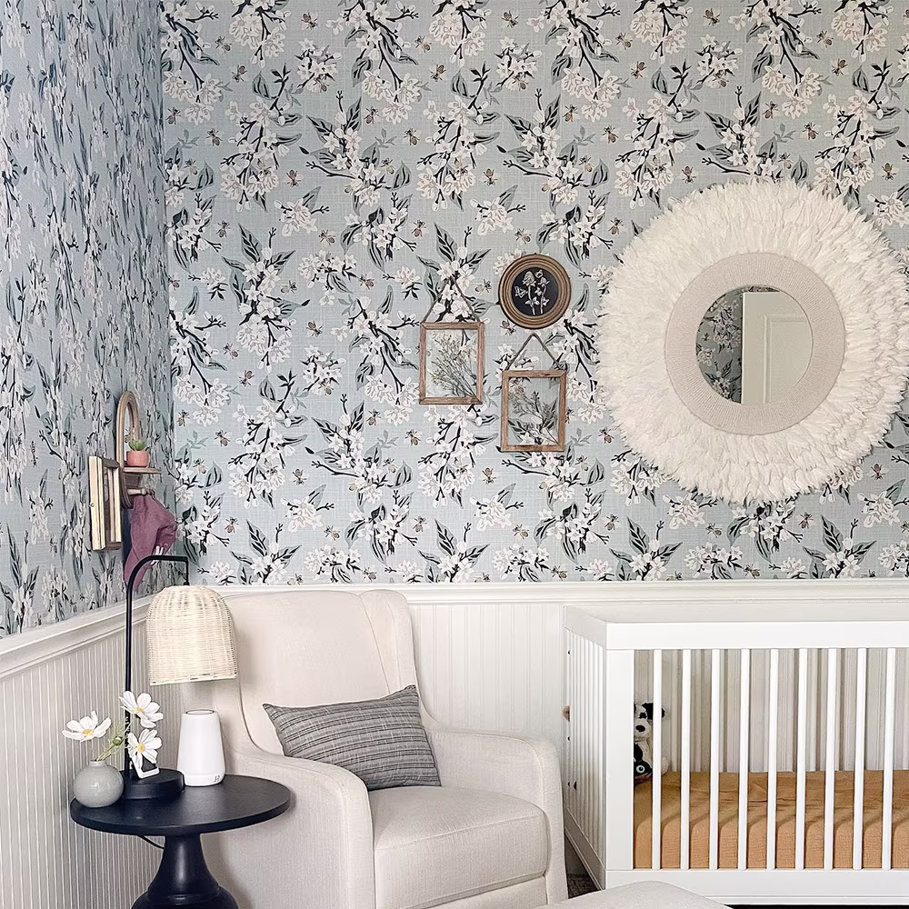 Nursery with blue floral wallpaper.