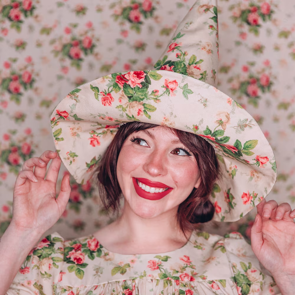 Keiko Lynn wearing a floral witch hat and matching dress.
