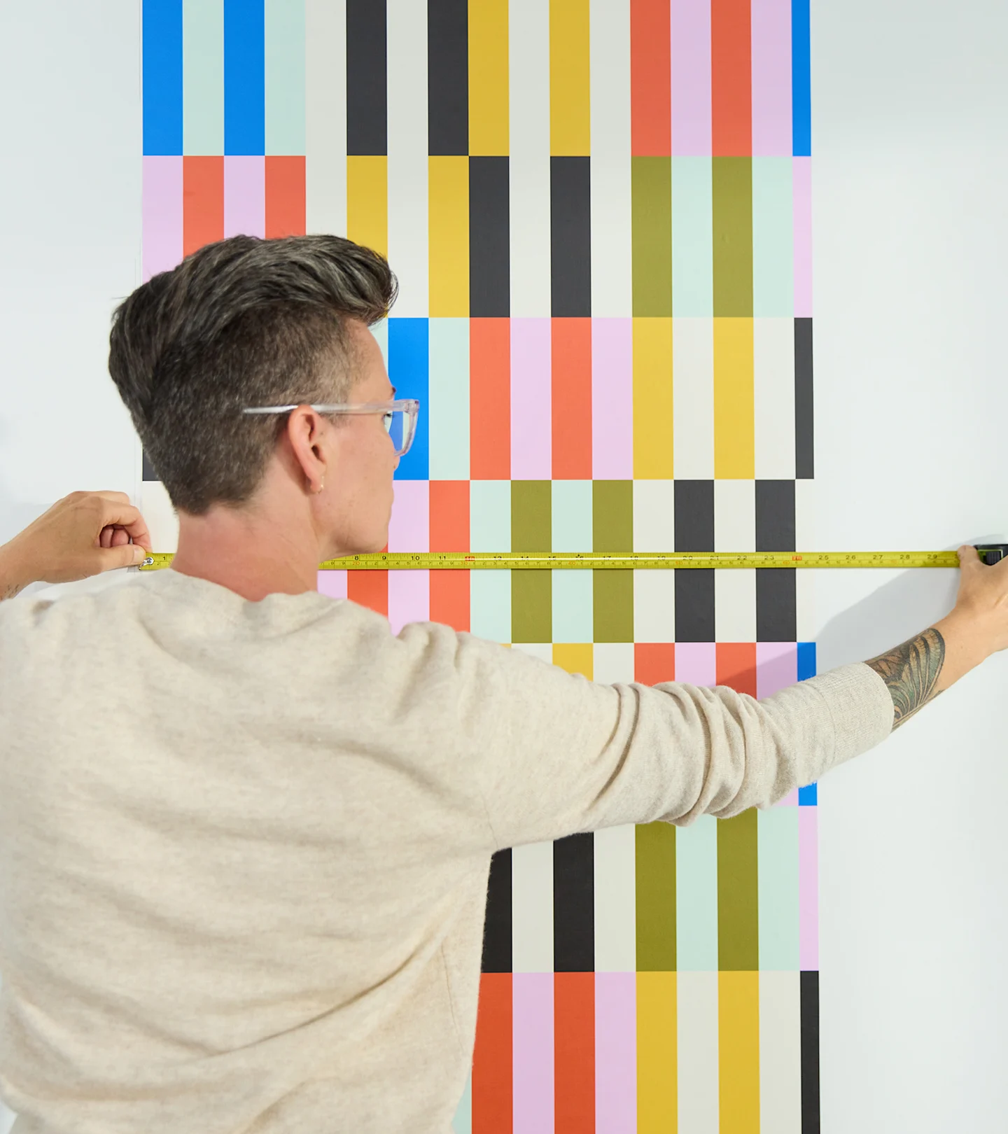 Person measuring the repeat on a roll of wallpaper.