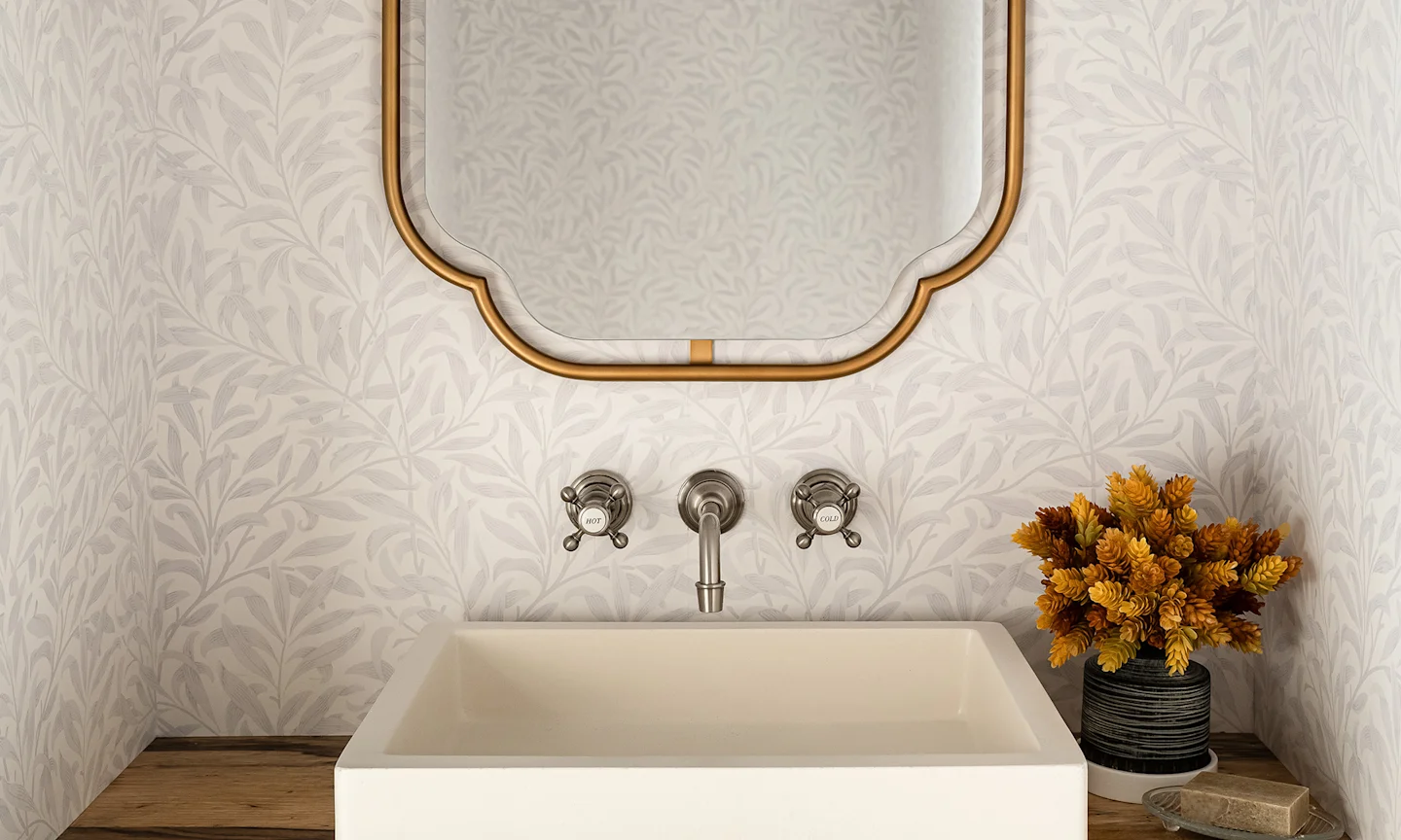 Bathroom with cream Willaim Morris style leaves wallpaper.