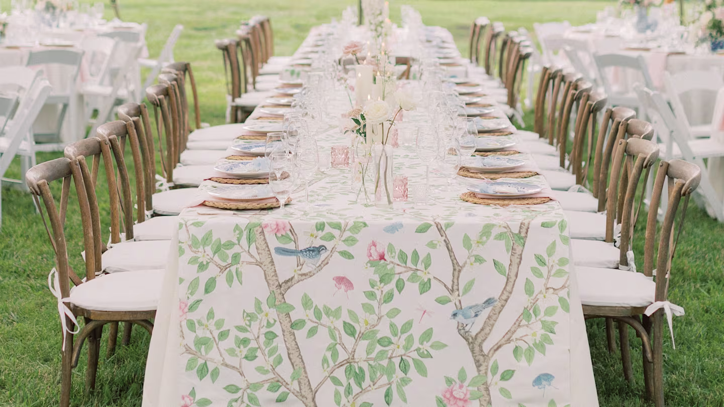 Long event table with many wooden chair and nature design table runner.