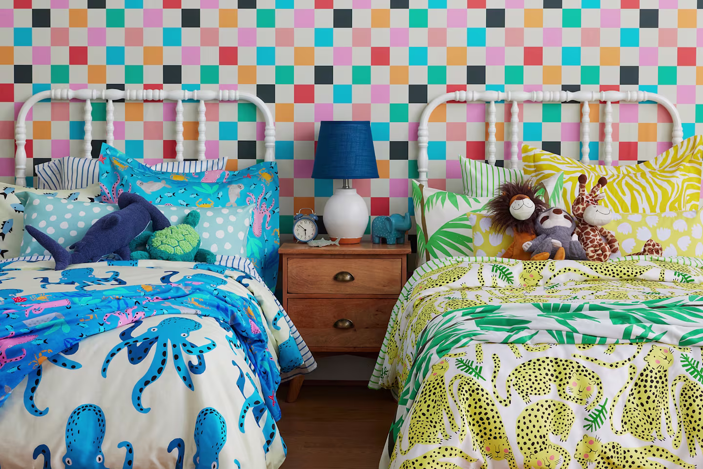 Two kids twin beds one with blue octopus bedding and one with yellow tiger bedding