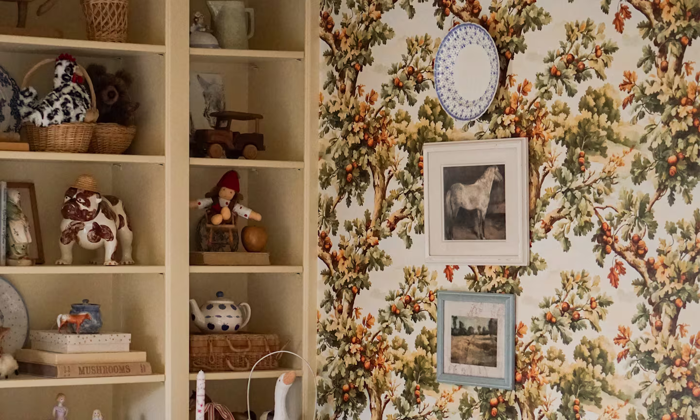 Playroom with oak tree wallpaper and open shelving.